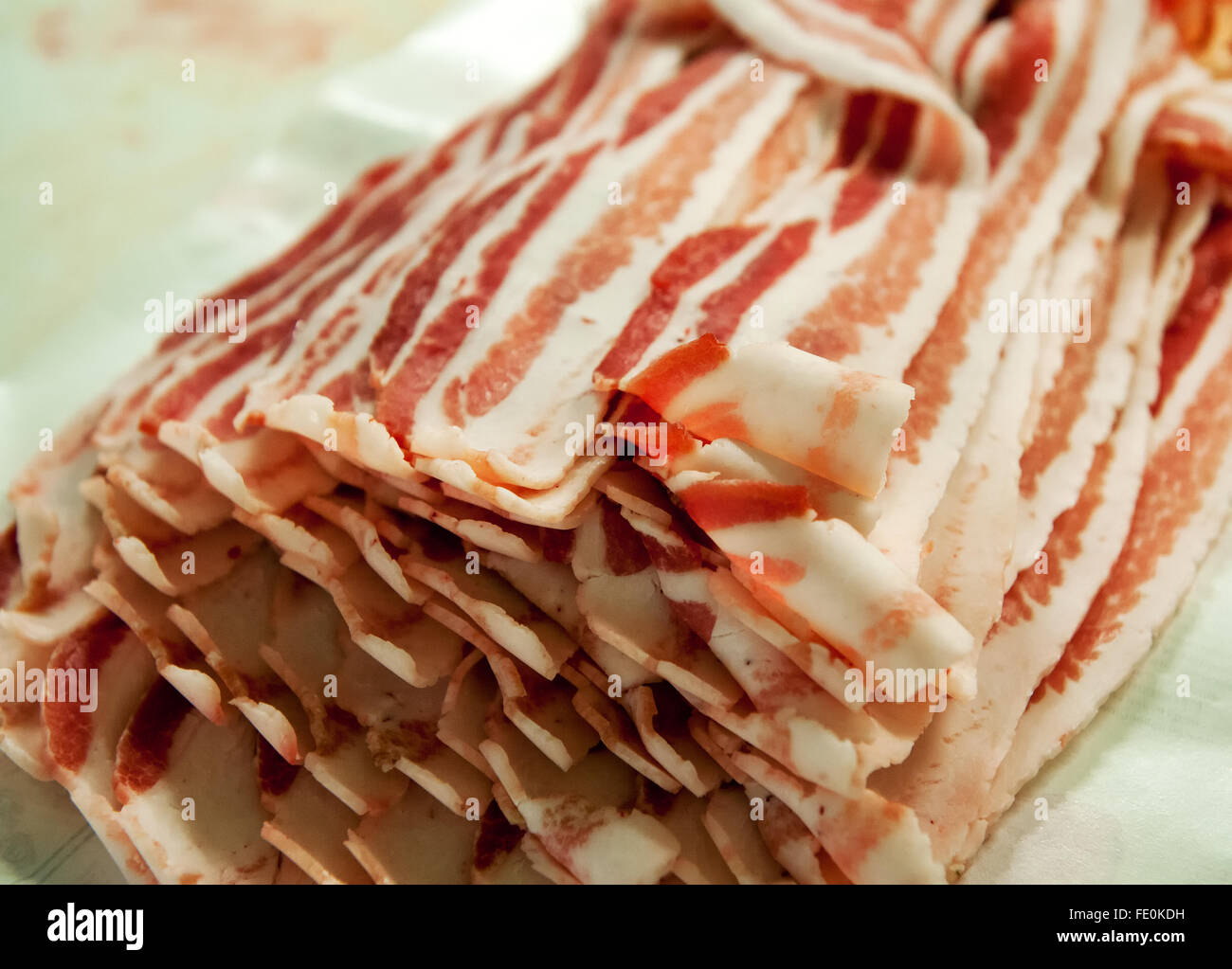 In prossimità di molte fette di pancetta in bundle su tavola in impianto per la trasformazione di carni Foto Stock