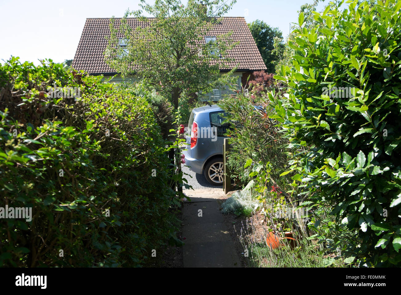 Giardino anteriore e il percorso che conduce alla macchina parcheggiata sulla strada, Bawdsey, Suffolk, Regno Unito. Foto Stock