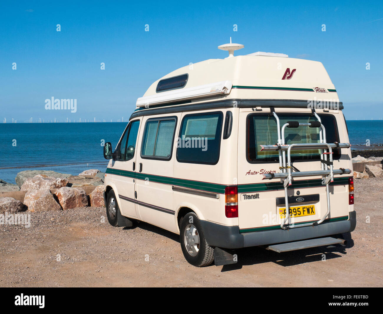 Flair Ford Auto-sleeper camper parcheggiato fino sul mare guardando wind farm Foto Stock