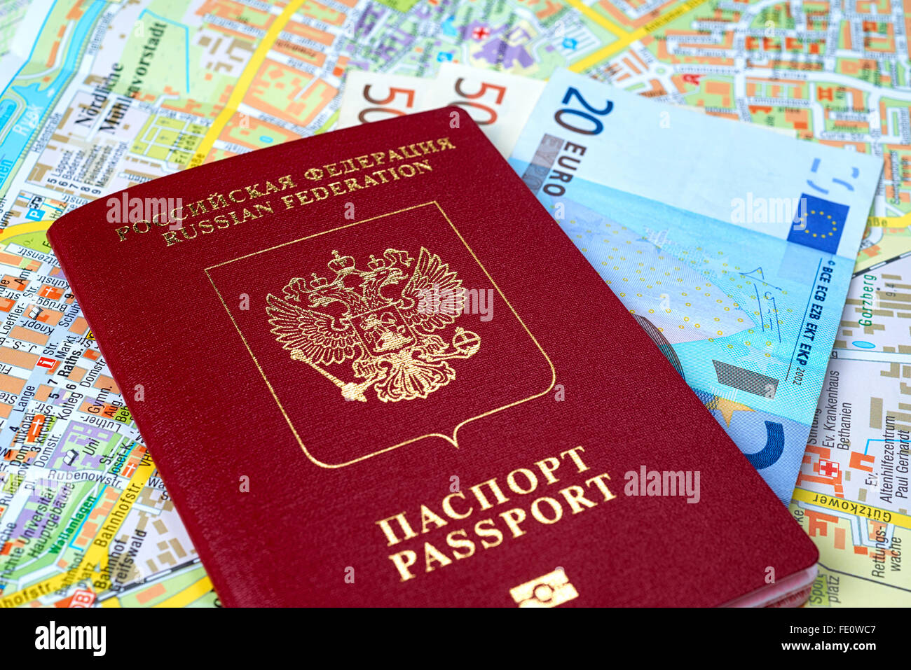 Passaporto russo e le banconote in euro sullo sfondo della mappa Foto Stock