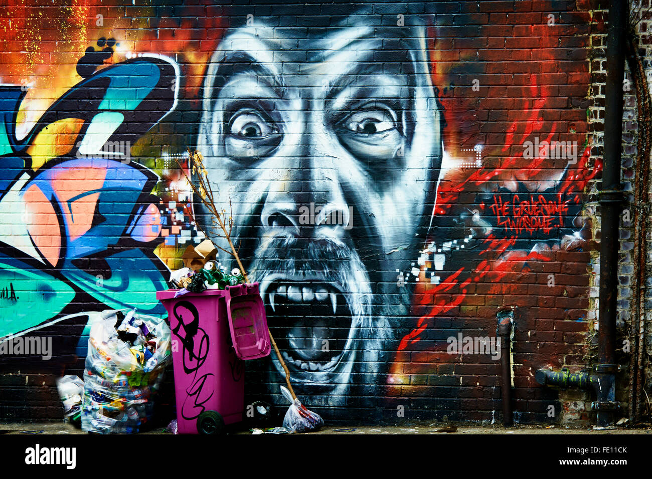 Altamente colorato design Graffiti e faccia con la vita reale bidoni della spazzatura Foto Stock