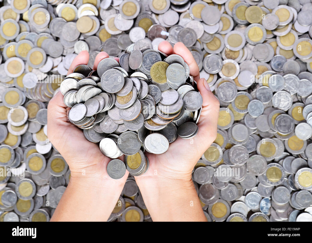 Un sacco di monete nelle mani Foto Stock