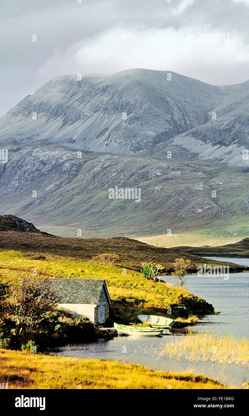 Casa in barca sulle rive di Loch più in N W Highlands scozzesi con Arkle montagna dietro. La Scozia, Regno Unito Foto Stock