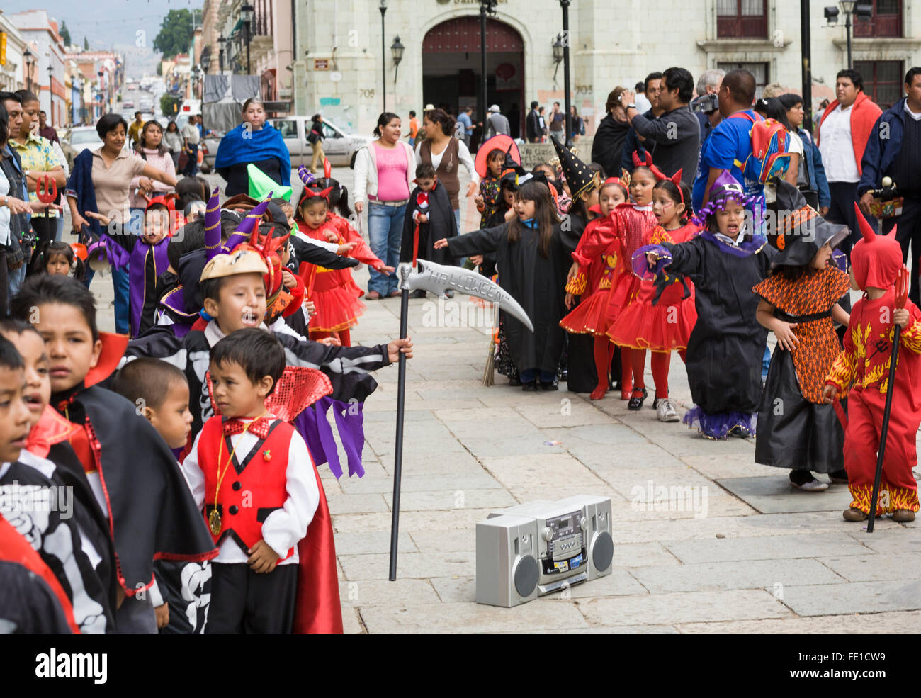 I bambini in costume dancing e marciando per la riproduzione di musica da una boom box in un Halloween Parade, città di Oaxaca, Oaxaca, Messico Foto Stock