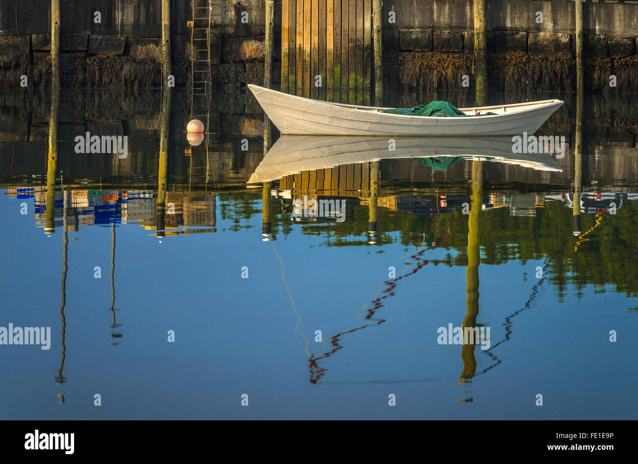 Stonington, Maine: sole di mattina sulla barca bianca e molo riflessioni, Stonington Harbor Foto Stock