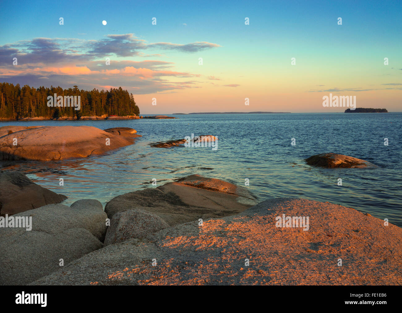 Deer Isle, Maine: luce della sera e il sorgere della luna sulla costa rocciosa di cervi Isola Foto Stock