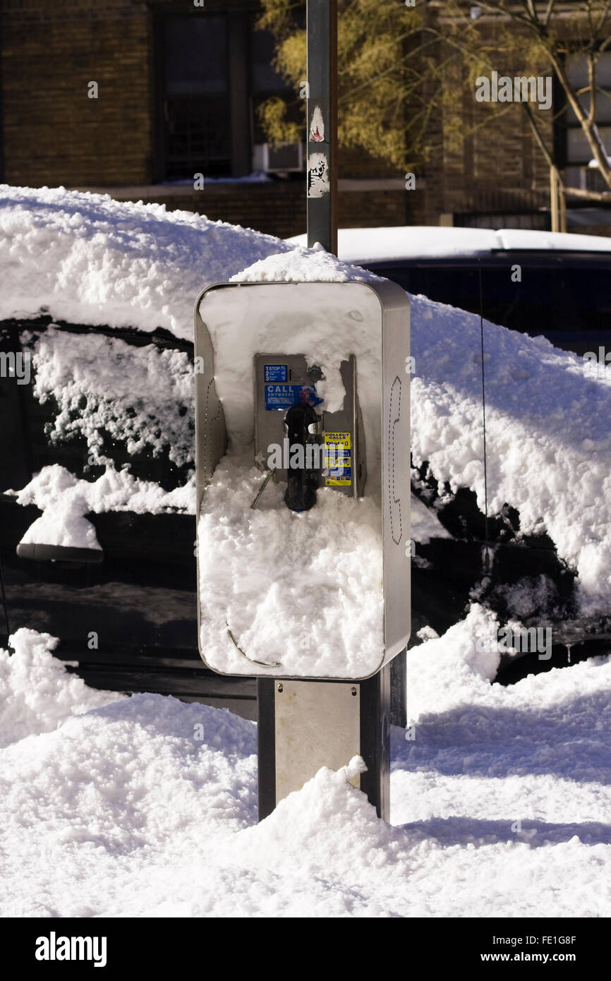 Un telefono pubblico stand coperto di oltre 2 metri di neve il mattino dopo una notte di blizzard Foto Stock