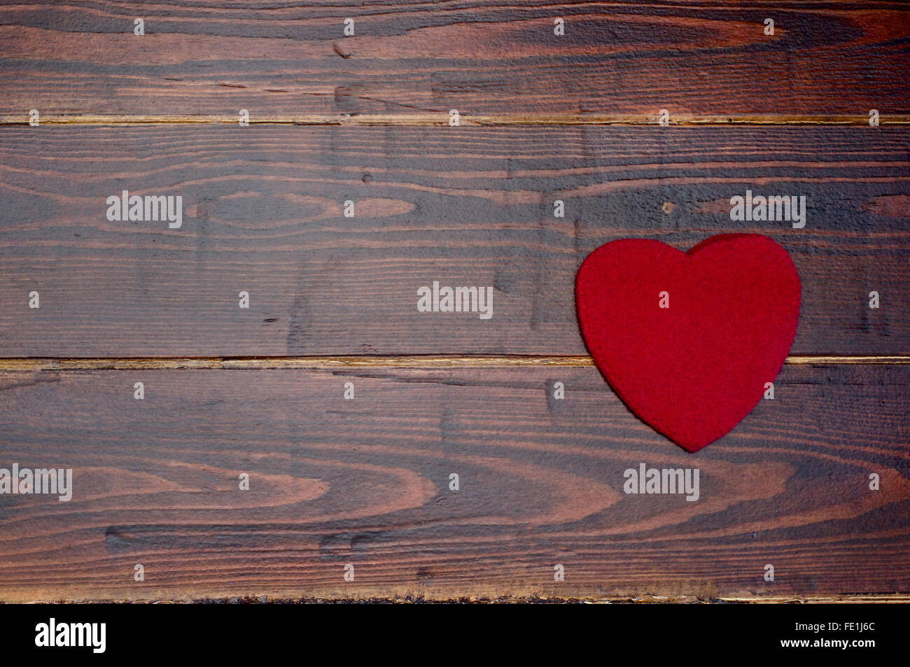 La lana cuore rosso marrone su uno sfondo di legno Foto Stock