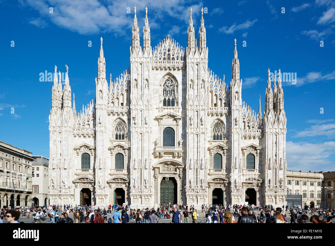 Milano Duomo cattedrale gotica facciata e persone di passaggio in un assolato pomeriggio estivo Foto Stock