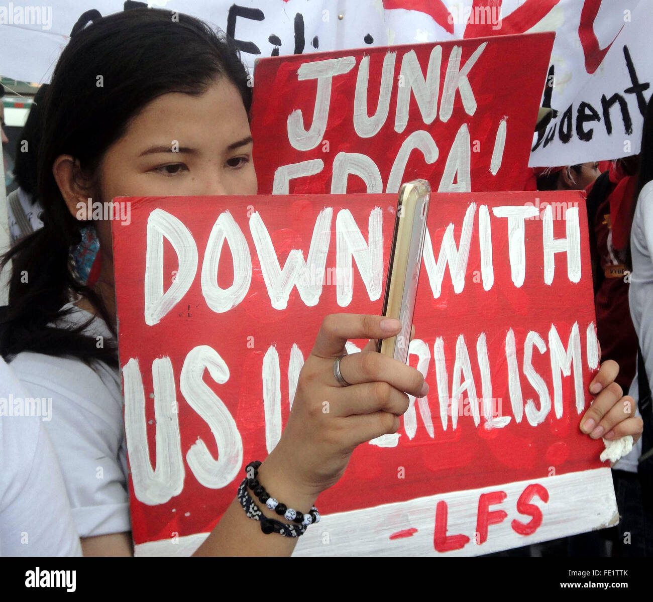 Un manifestante utilizza un telefono cellulare per registrare un rally di protesta contro la legittimità della difesa rafforzata cooperazione (EDCA) davanti all'Ambasciata degli Stati Uniti a Manila nelle Filippine. Un accordo che consente la maggiore presenza di noi forze militari per la formazione nelle Filippine è costituzionale, il paese del Sudest asiatico, la Corte suprema ha deciso. La decisione è venuto in mezzo a tensione crescente tra la Cina e le Filippine su una riga territoriale nel Mare della Cina del Sud. Ai sensi dell'accordo, gli Stati Uniti saranno ammessi per la costruzione di strutture, negozio così come armi di posizione, forniture di difesa e di mate Foto Stock