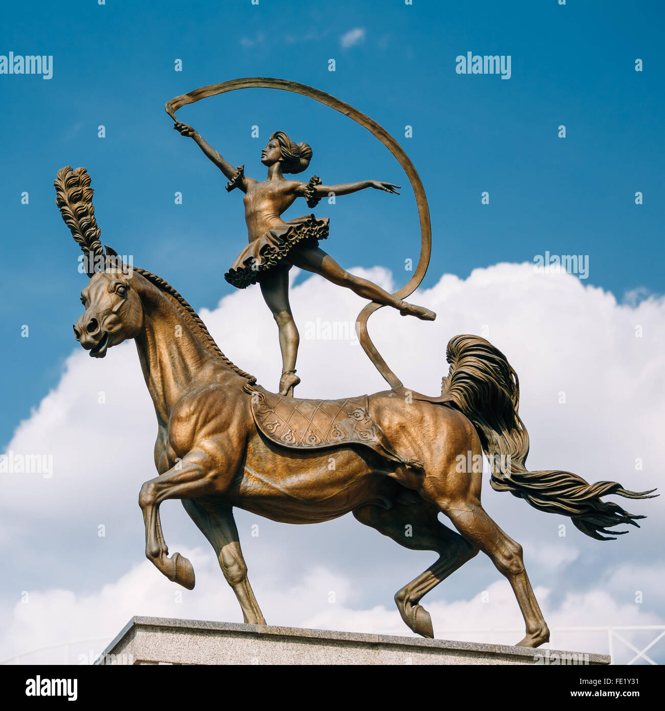 La scultura in bronzo di ragazza ginnasta equilibratura su circus cavallo vicino al Circo di Stato a Minsk, in Bielorussia. Bianco blu cielo dello sfondo. Foto Stock