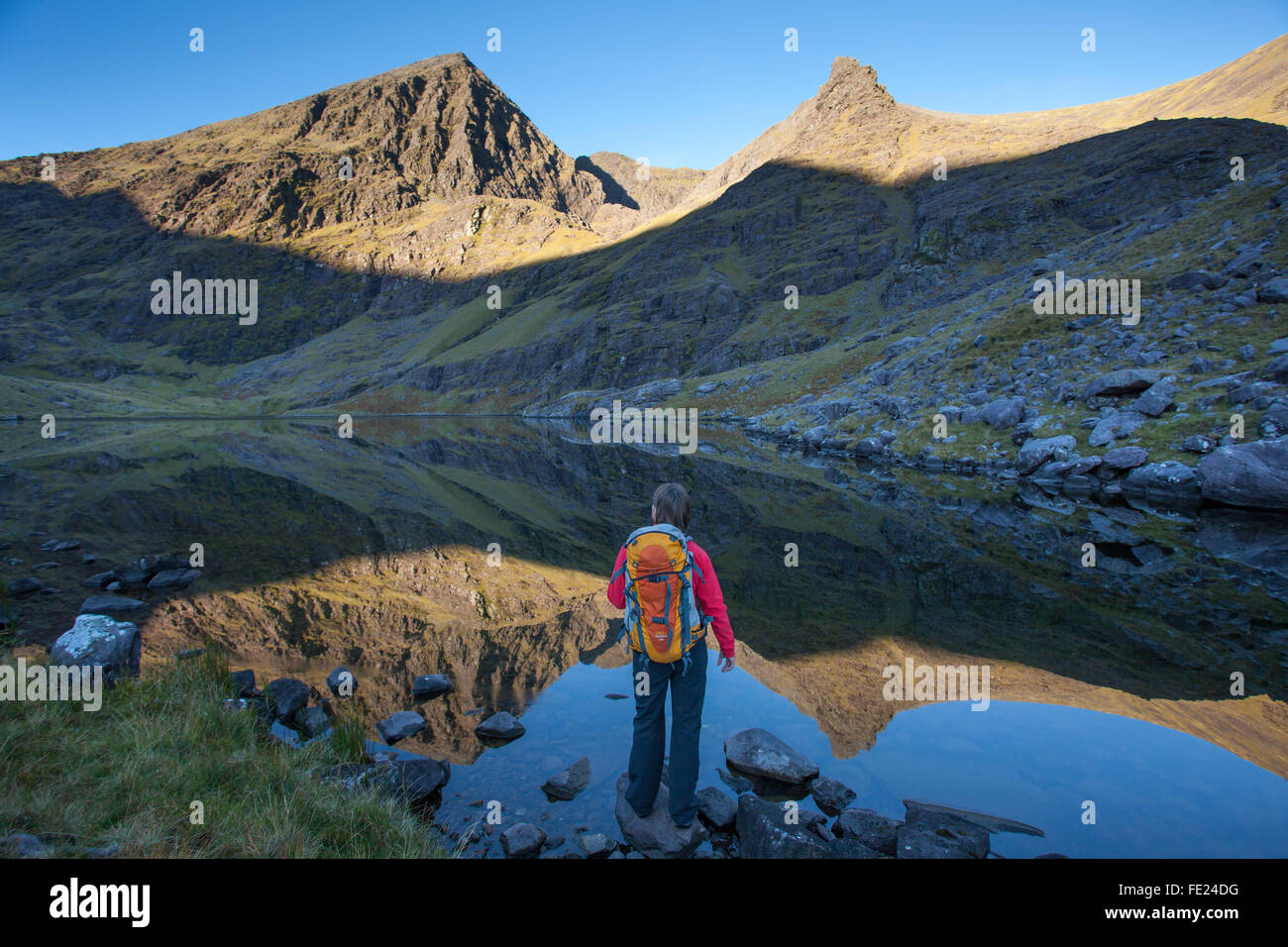 Walker e Lough Gouragh sotto Carrauntoohil, Hag's Glen, del MacGillycuddy Reeks, nella contea di Kerry, Irlanda. Foto Stock