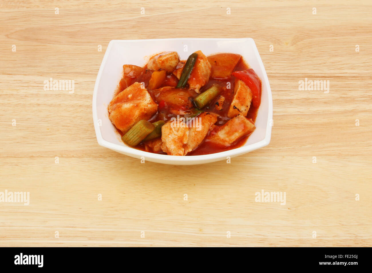 Pasto cinese, Kung Po il pollo in una ciotola su una tavola di legno Foto Stock