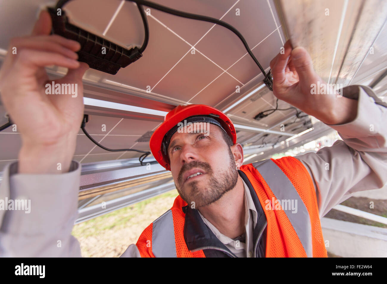 Il solare fotovoltaico installer funzionante su collegamenti di alimentazione per un array PV Foto Stock