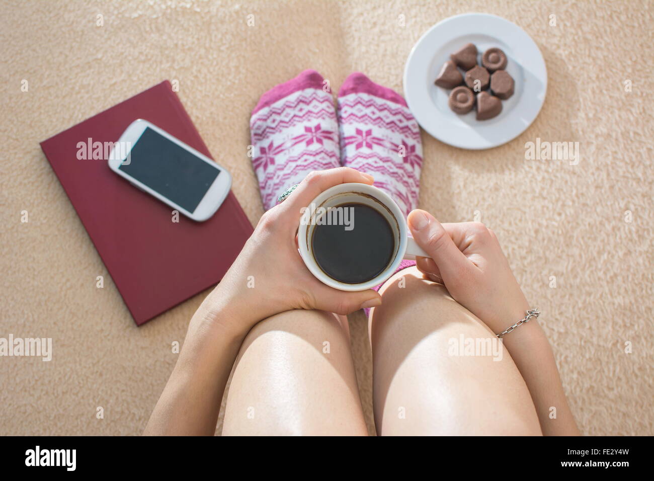 Ragazza avente il caffè a letto dotate di accessori per il tempo libero e gli spuntini Foto Stock