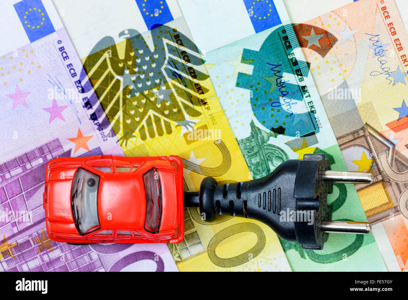Giocattolo auto, spina e aquila federale di Germania sulle banconote in euro, auto elettrica bonus Foto Stock