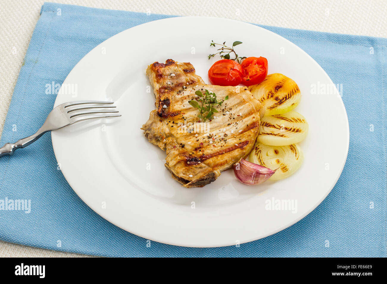 Succosa braciole di maiale alla griglia con anelli di cipolla e la forcella, vista dall'alto Foto Stock