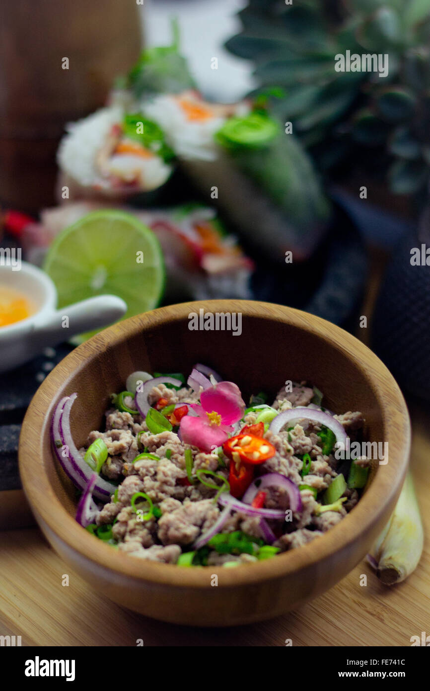 Thailändische Vietnamesische Schweinefleisch Spezialität larb moo serviert auf Bambus Servierplatte mit bunter Südostasiatischen Foto Stock