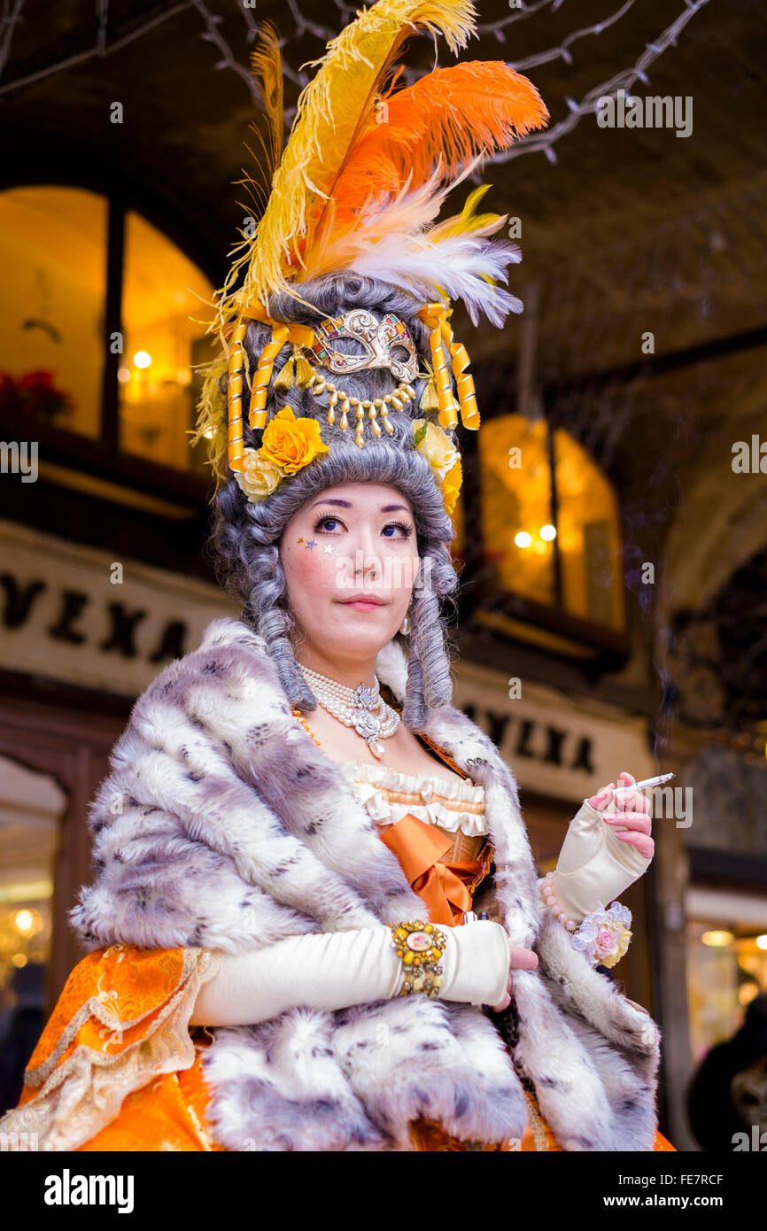 Una donna adulta di fumare in un costume durante il carnevale