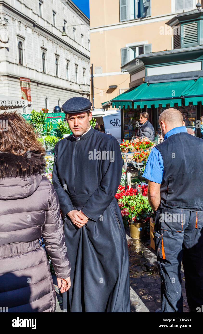 Sacerdote cattolico che indossa una cassock e un cappello piatto in un mercato dei fiori, Roma, Italia. Foto Stock