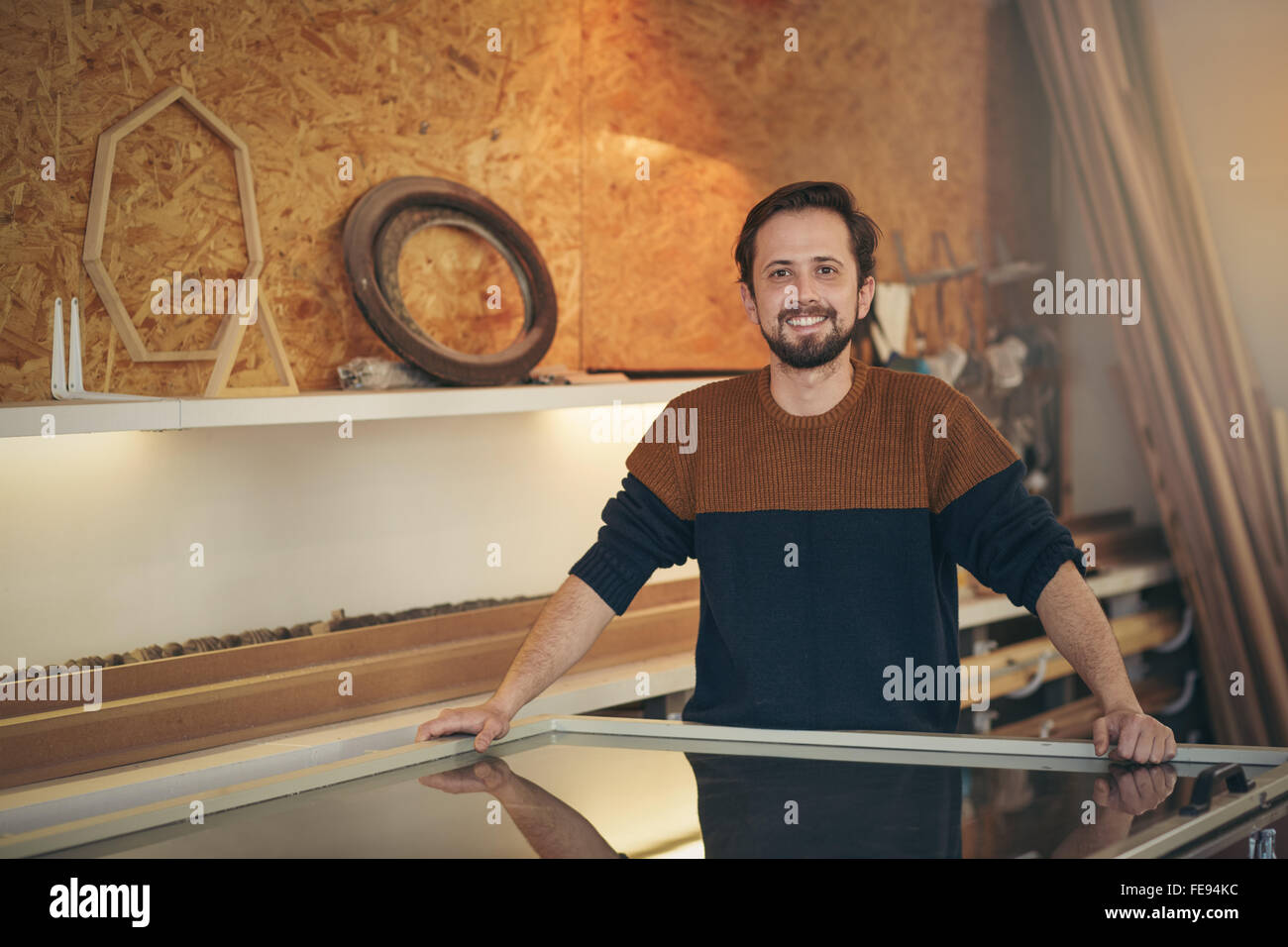 Artigiano positivamente permanente nel suo studio di design cercando orgoglioso e fiducioso Foto Stock