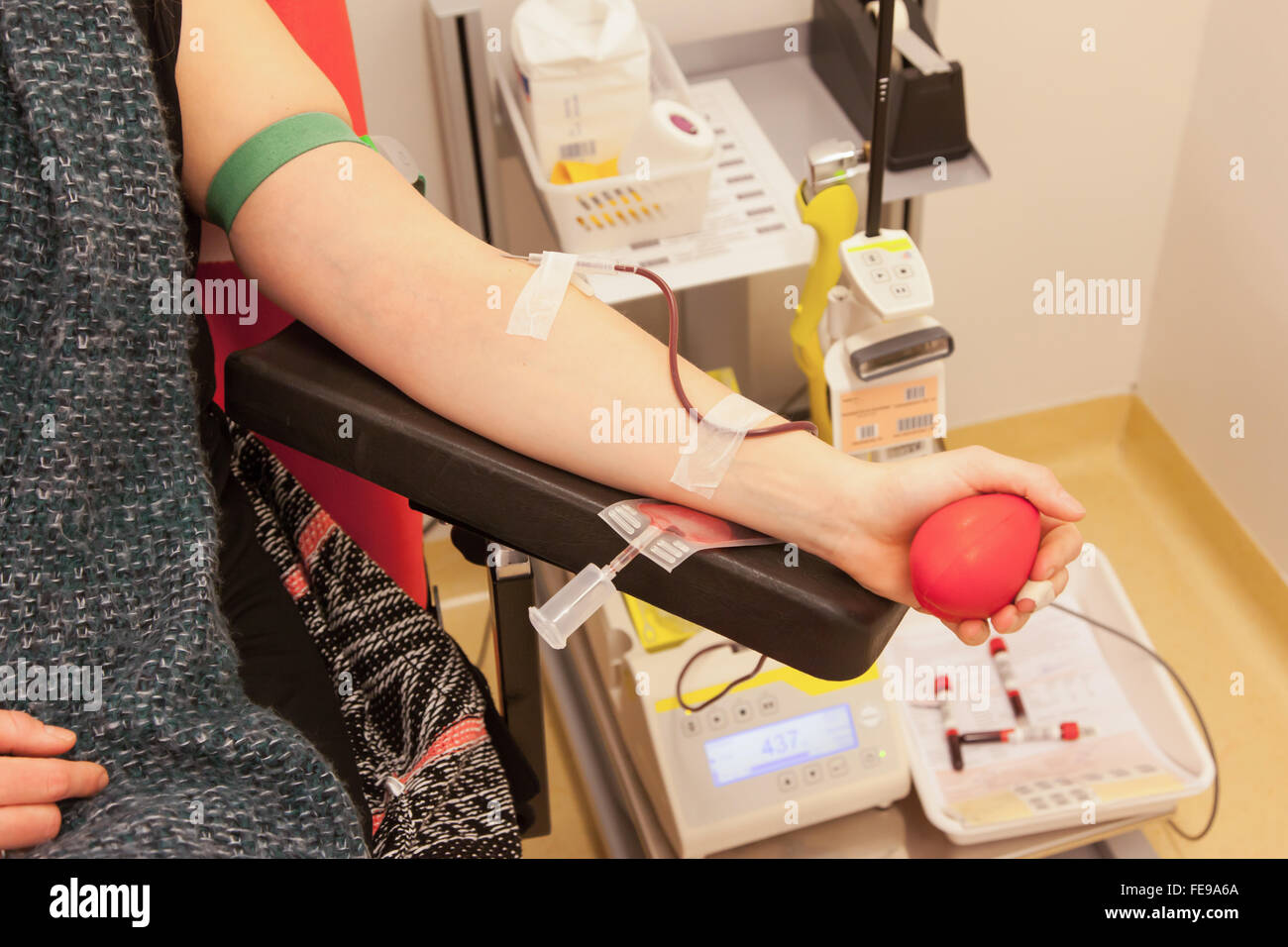 Donatore in una poltrona dona il sangue alla stazione hemotransfusion, il fuoco selettivo Foto Stock