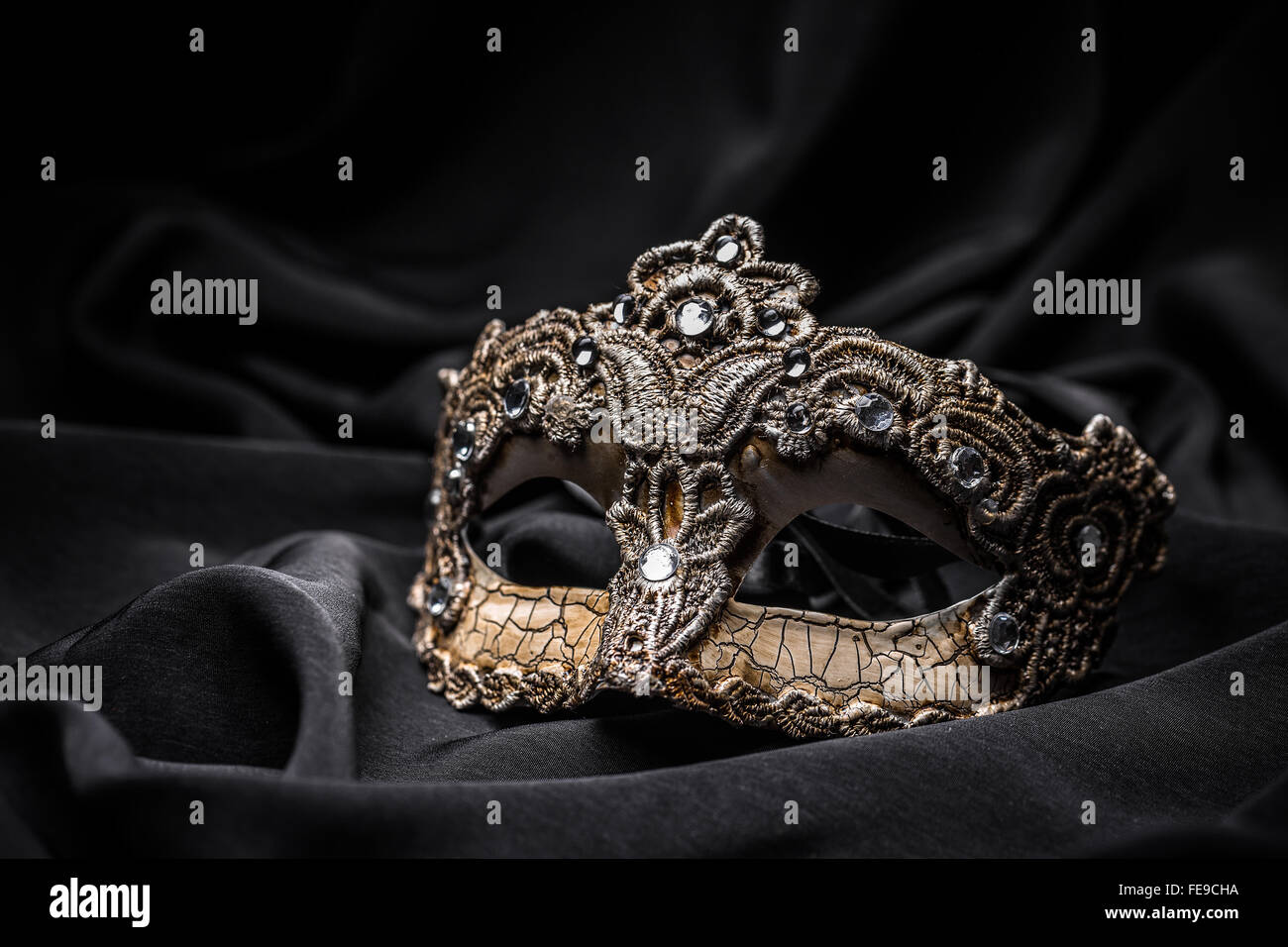 Carnevale marrone maschera nera su sfondo di seta Foto stock - Alamy