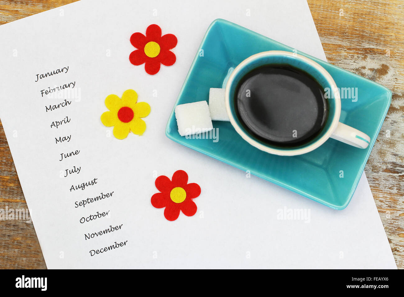 Mesi scritto sul pezzo di carta bianco con tazza di caffè e fiori colorati Foto Stock