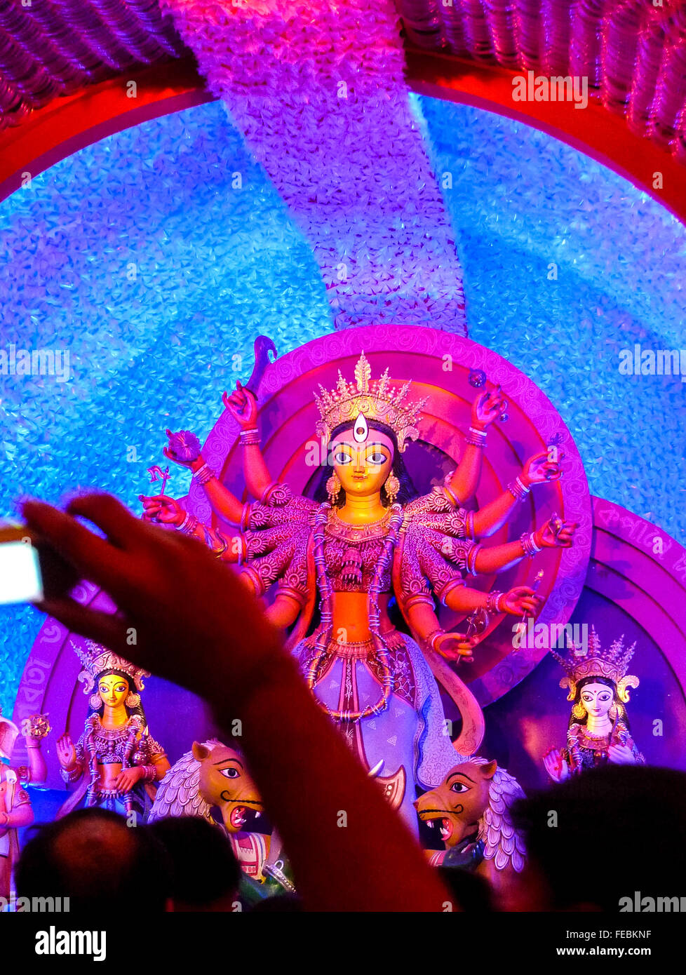 Durga dea idolo illuminato in sfumature di rosa in un pandal Foto Stock