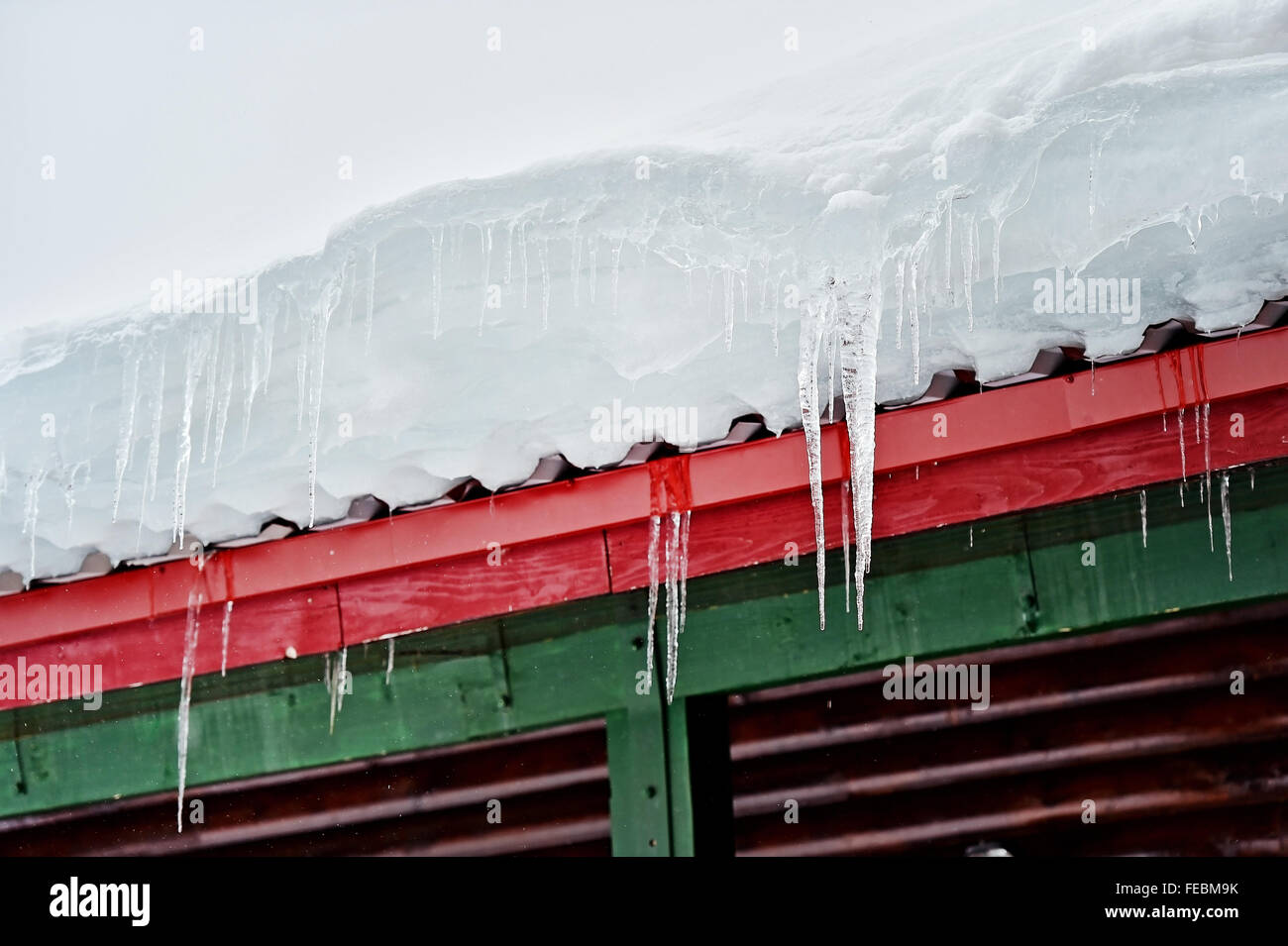 Inverno dettaglio con fusione ghiaccioli su un chalet in legno Foto Stock