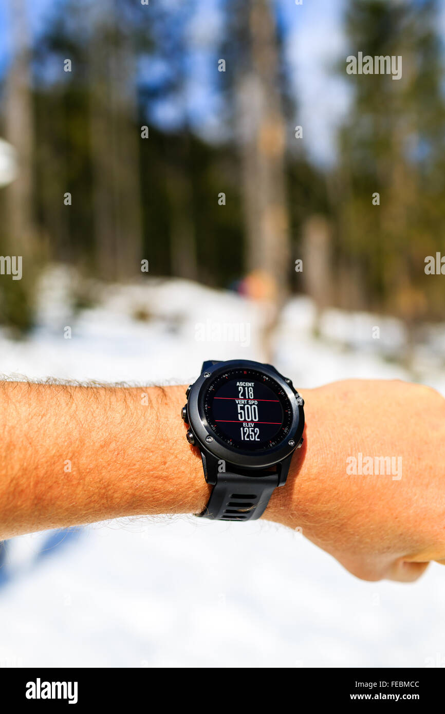 Guida sul sentiero di montagna guardando il cronometro smartwatch, activity monitor tracker, controllo delle prestazioni o la frequenza cardiaca impulso. Foto Stock