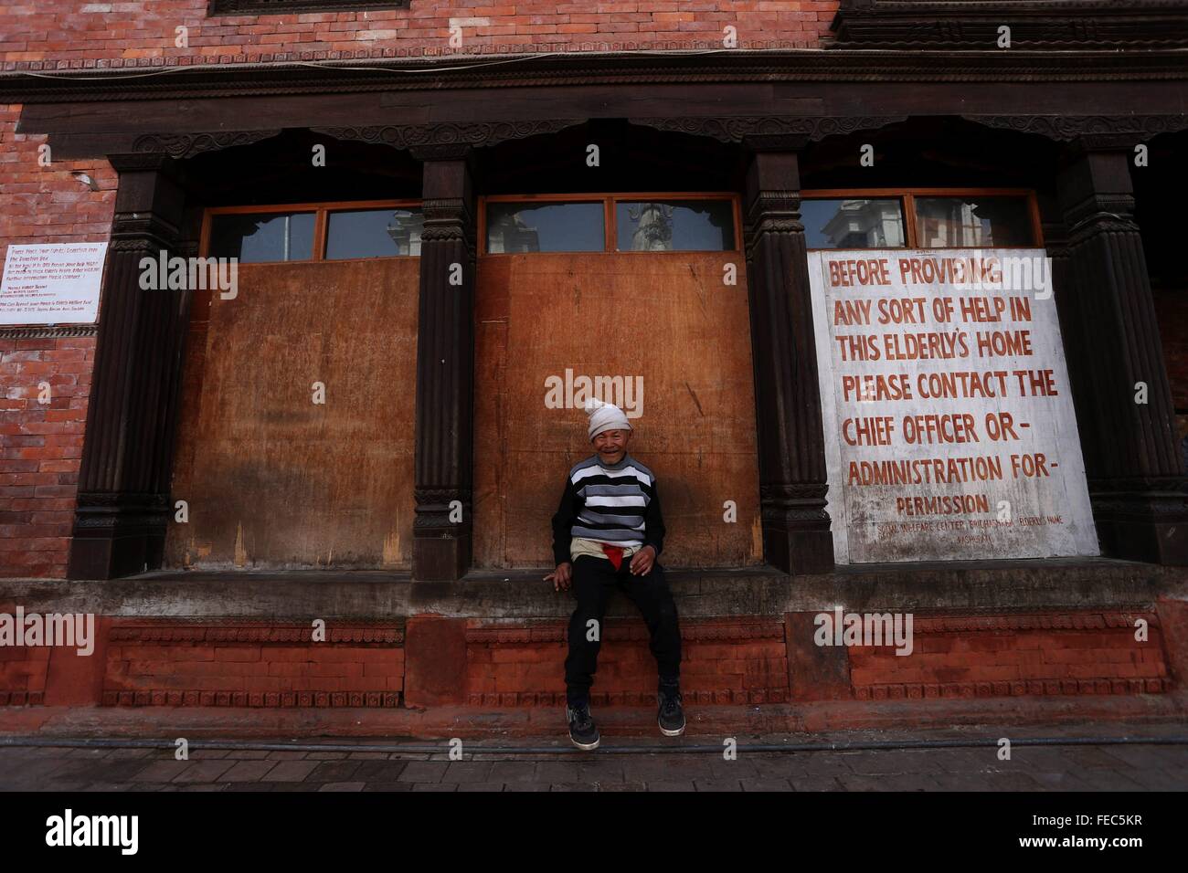 Kathmandu, Nepal. 5 febbraio, 2016. Un uomo anziano si siede di fronte a una casa vecchia situata in corrispondenza di Pashupati, Kathmandu, Nepal, Febbraio 5, 2016. Più di 150 persone anziane costrette a rimanere nella vecchiaia case, molte delle quali sono state danneggiate dal sisma, in quanto il governo non ha pianificato per una migliore rifugi. © Sunil Sharma/Xinhua/Alamy Live News Foto Stock