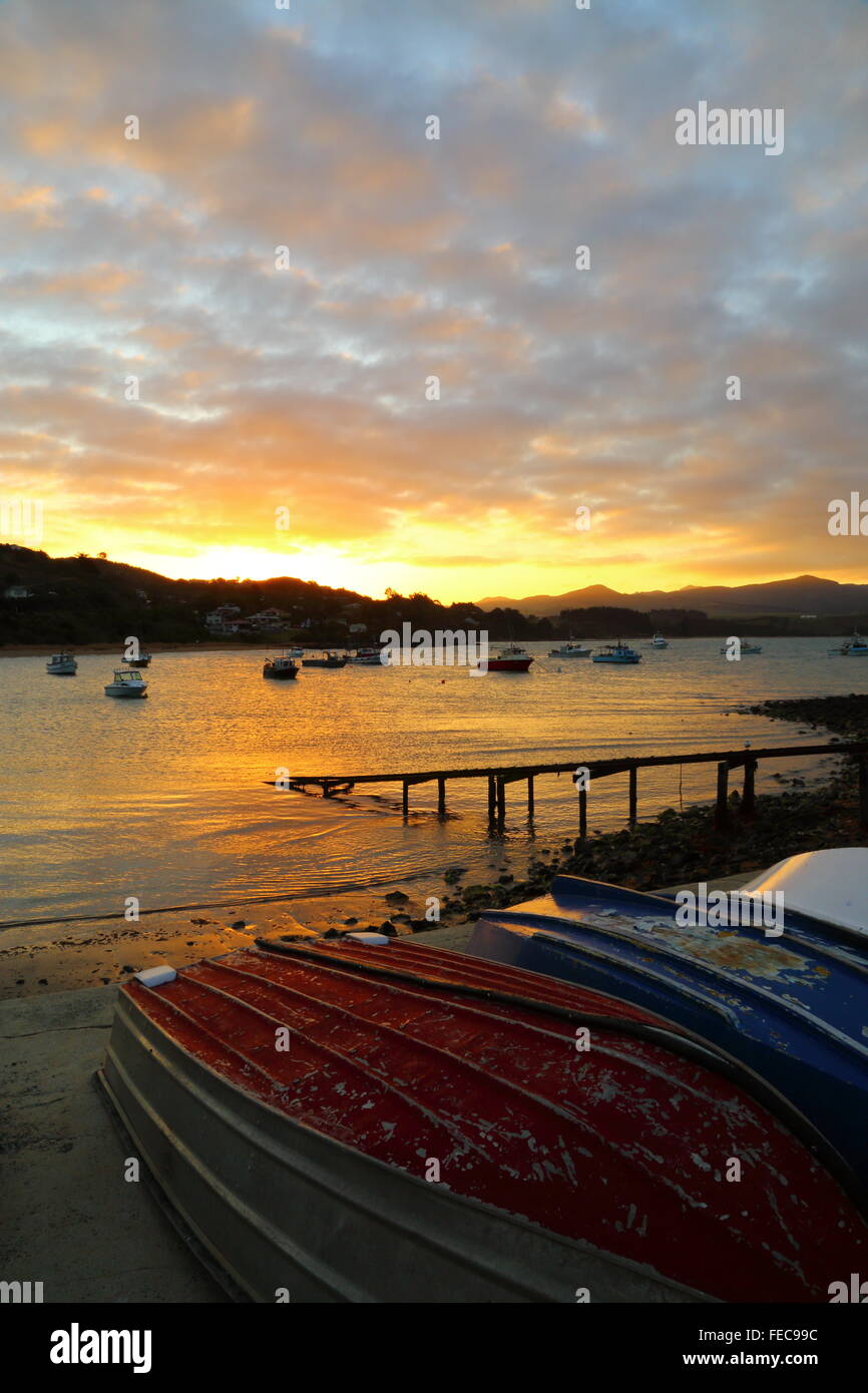 Barche da pesca a riposo nella baia di Moeraki durante il tramonto a Moeraki in Otago, Nuova Zelanda. Foto Stock