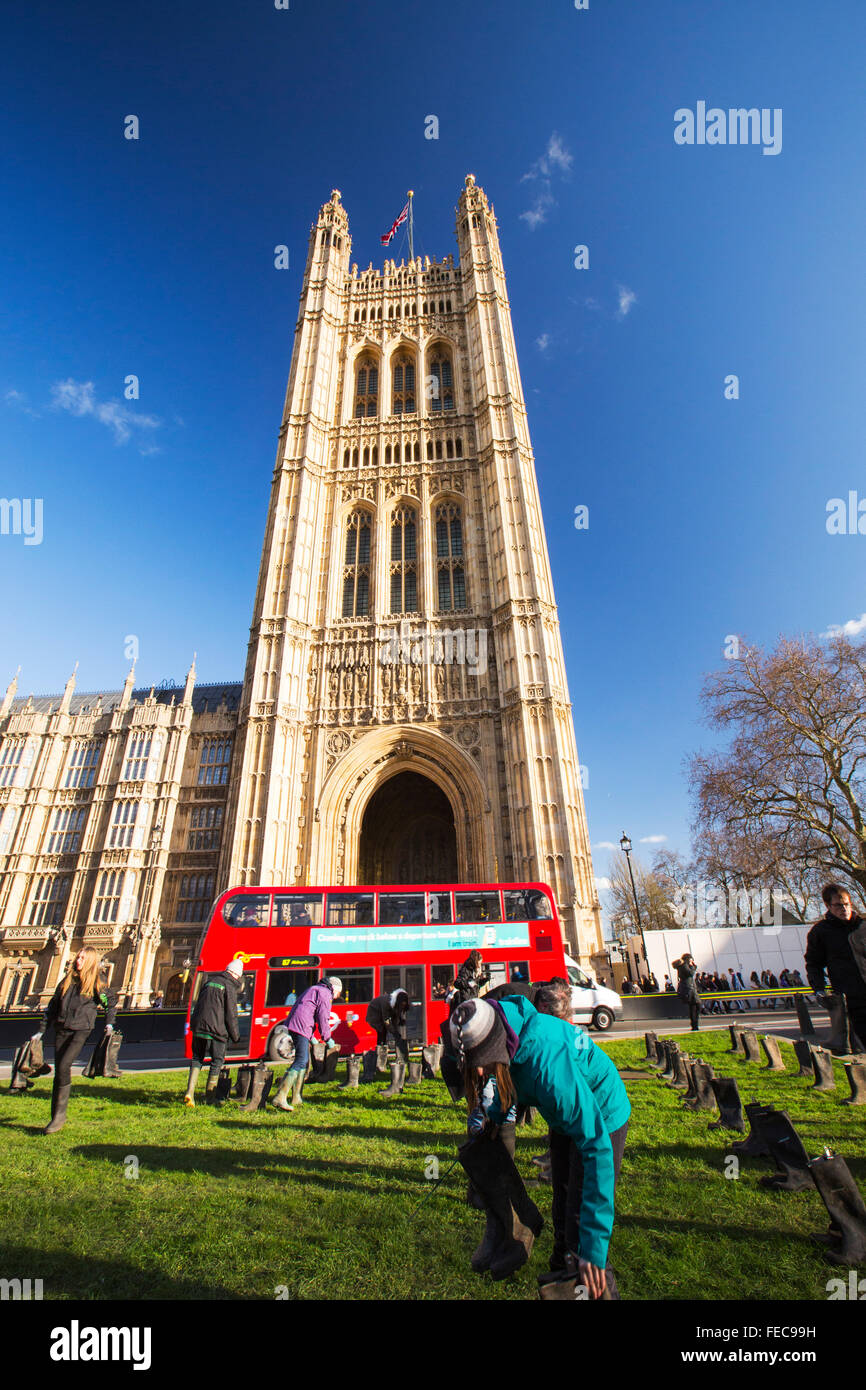 Giovedì 28 gennaio 2016 Greenpeace UK consegnato una petizione a Downing Street per protestare circa i recenti catastrofiche inondazioni. Come parte della giornata, un arte instalation di Stivali in gomma sono stati luogo fuori le case del Parlamento. Su ciascuna coppia di scarponi di un messaggio è stata attaccata da qualcuno che erano stati colpiti dalle inondazioni. Foto Stock