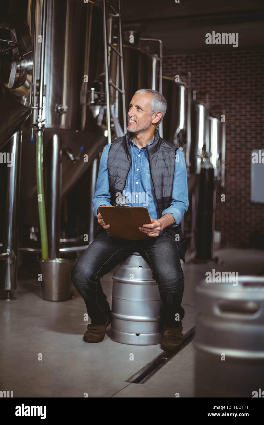 Fabbricante di birra locale la lettura nella pianta Foto Stock