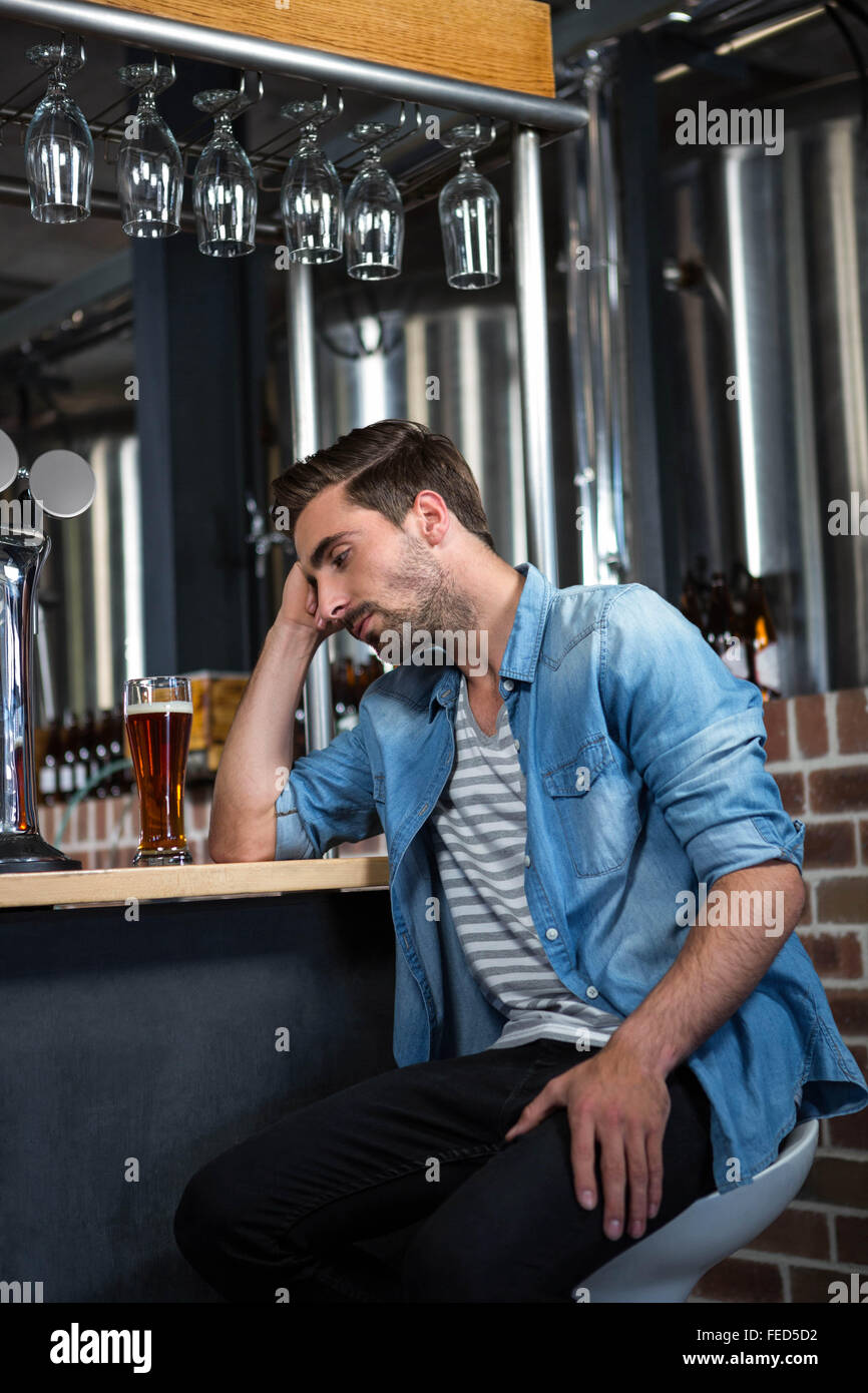 Stanco uomo appoggiata sul contatore Foto Stock