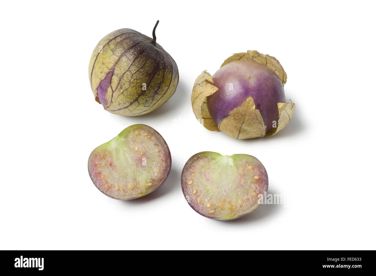 Tutto fresco e metà tomatillos nel loro lolla su sfondo bianco Foto Stock