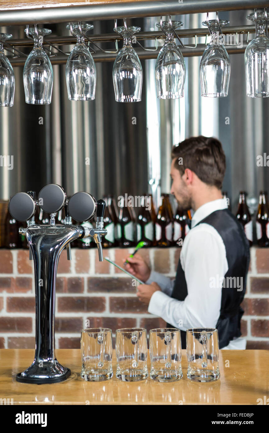 Bello il barman prendendo appunti su Appunti Foto Stock