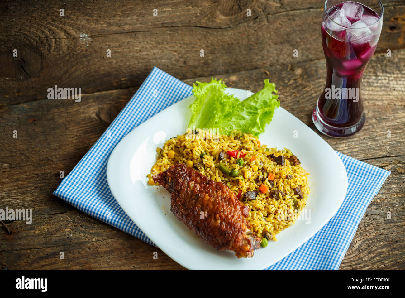 Deliziosi piatti di carne di tacchino con riso e foglie di insalata e un bicchiere di succo di frutta con ghiaccio Foto Stock