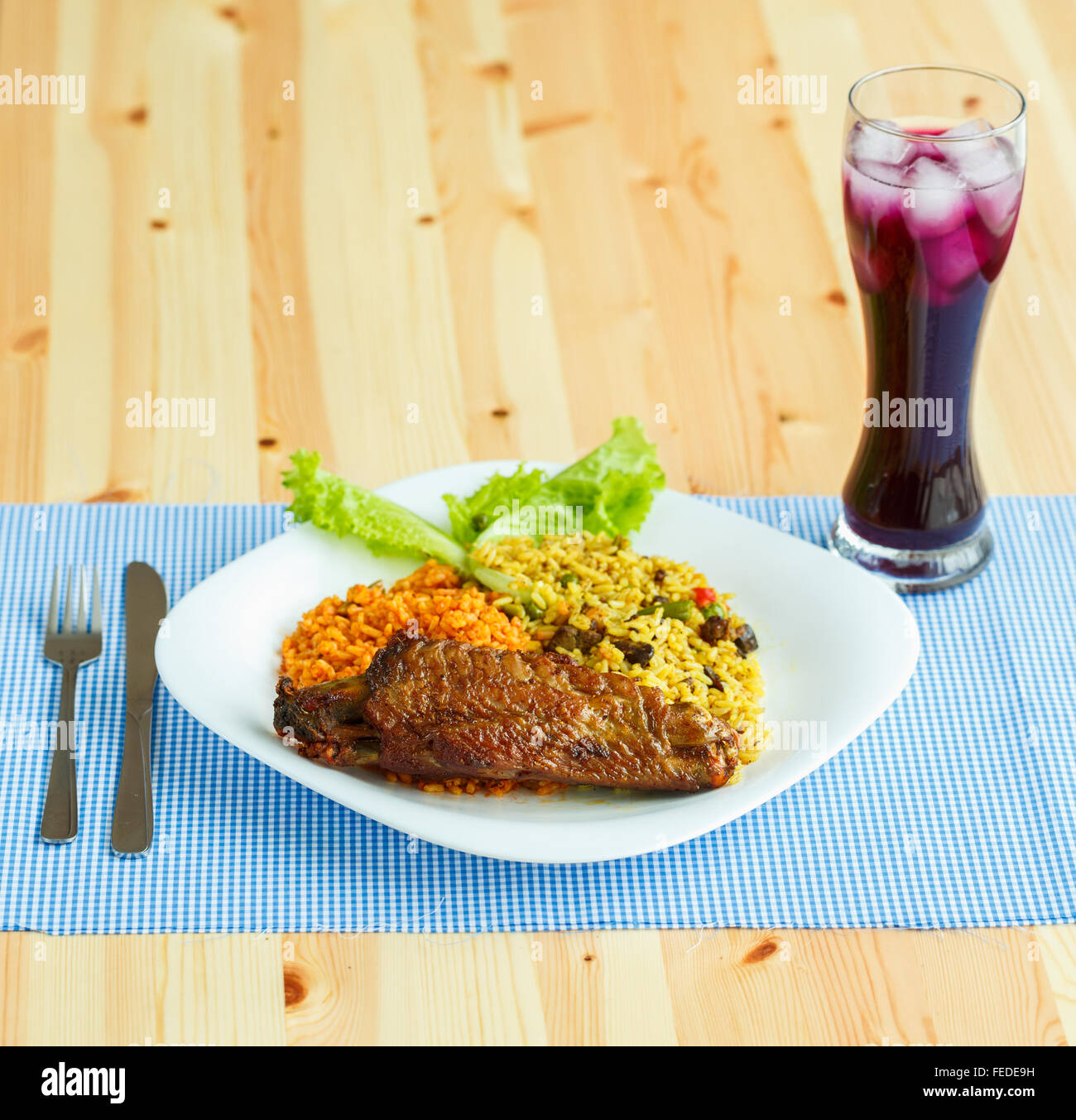 Deliziosi piatti di carne di tacchino con riso e foglie di insalata e un bicchiere di succo di frutta con ghiaccio Foto Stock