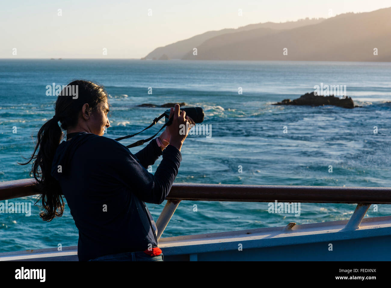 Donna fotografare sul ponte di una nave traghetto vicino alla bocca del canale di Tory Marlborough Sounds nuova Foto Stock