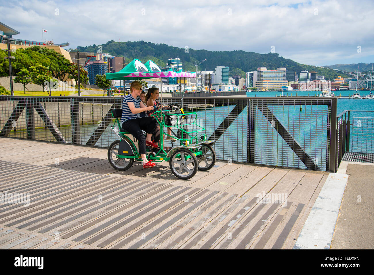 Famiglia in Surrey bike o quadracycle sul lungomare di Wellington, Nuova Zelanda Foto Stock