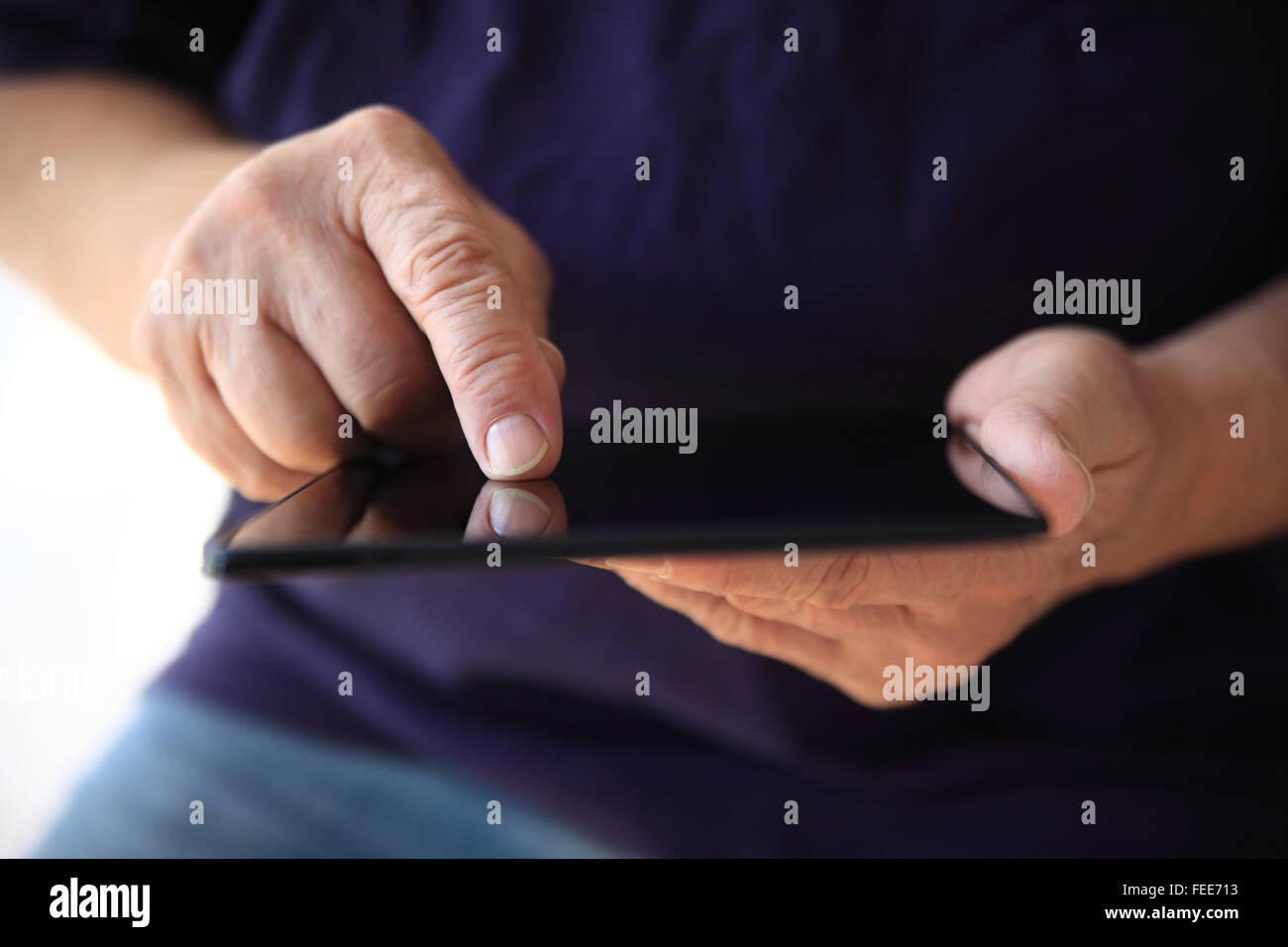 Un uomo cerca in internet sul suo tablet. Foto Stock
