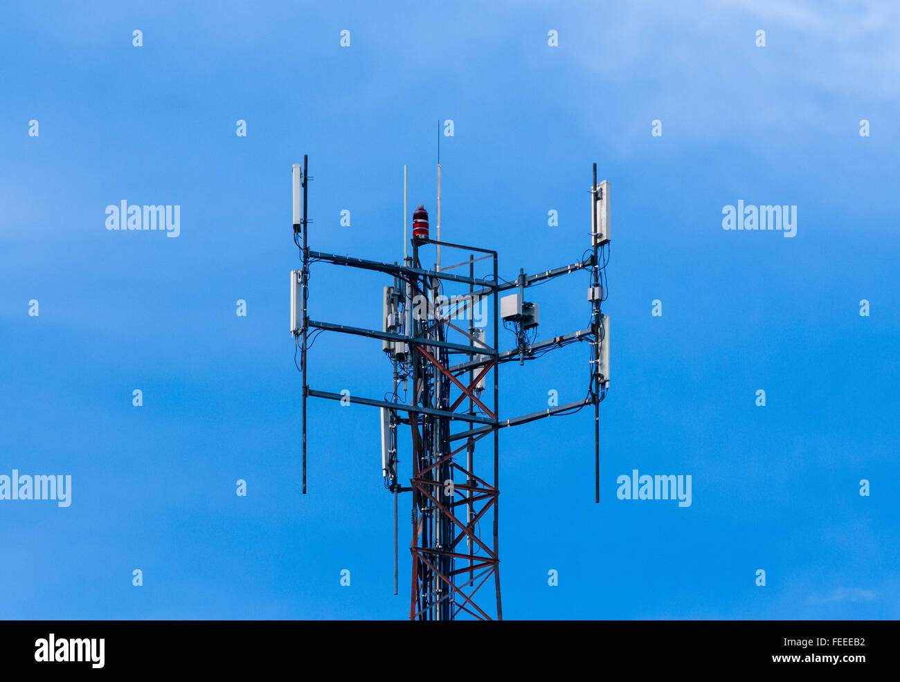 In alto di antenna di comunicazione montaggio attrezzature e il faro rotante contro il cielo blu. Foto Stock