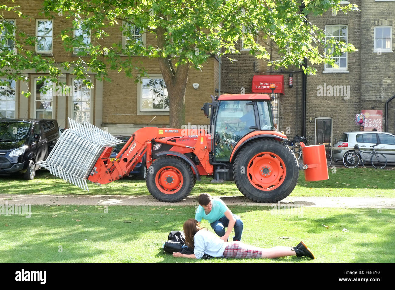 Un trattore in funzione su una pista attraverso un parco mentre trasportano le barriere pedonali. 6 Luglio 2014 Foto Stock