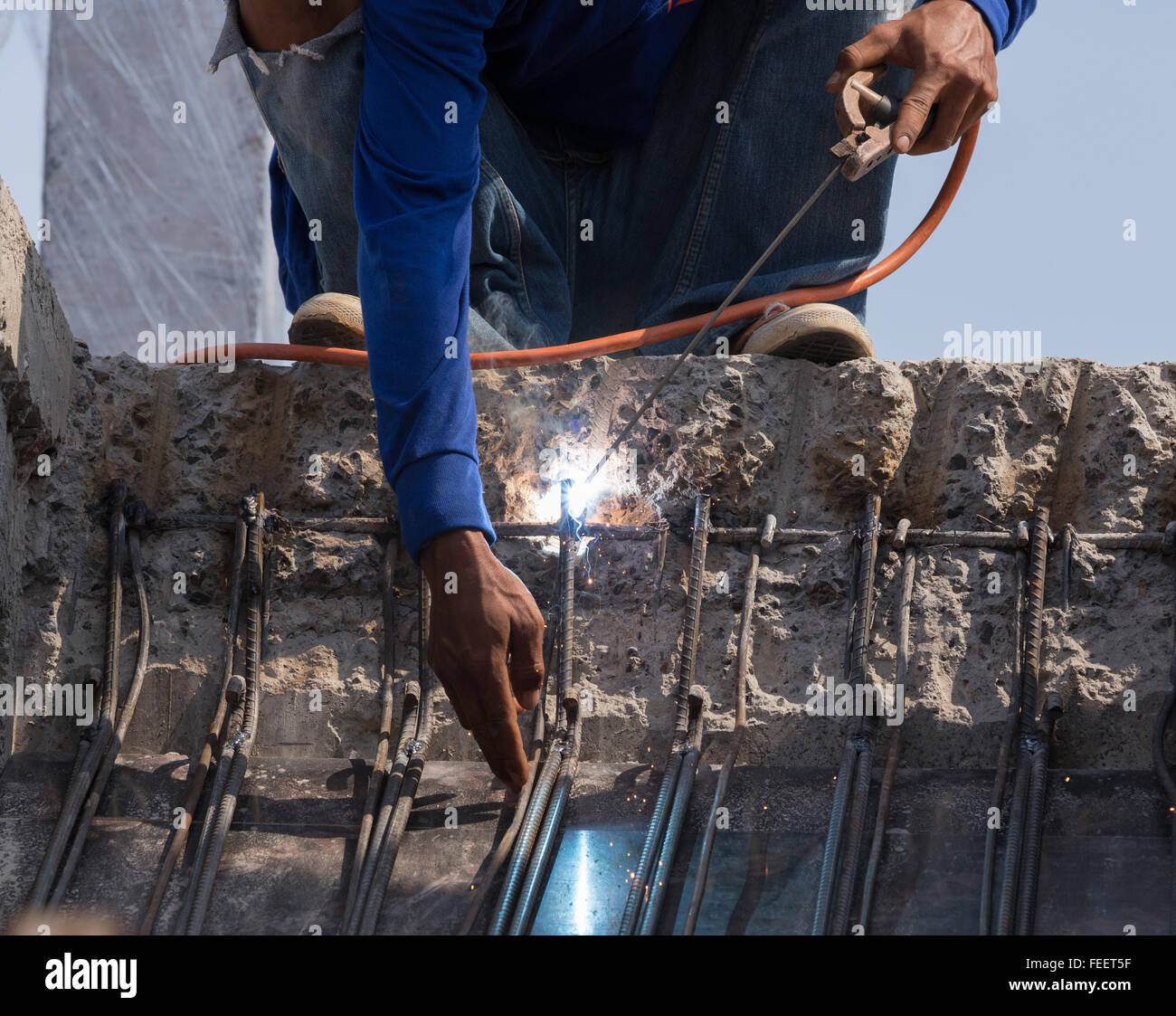Lavoratore di saldatura metallica in acciaio al sito in costruzione Foto Stock