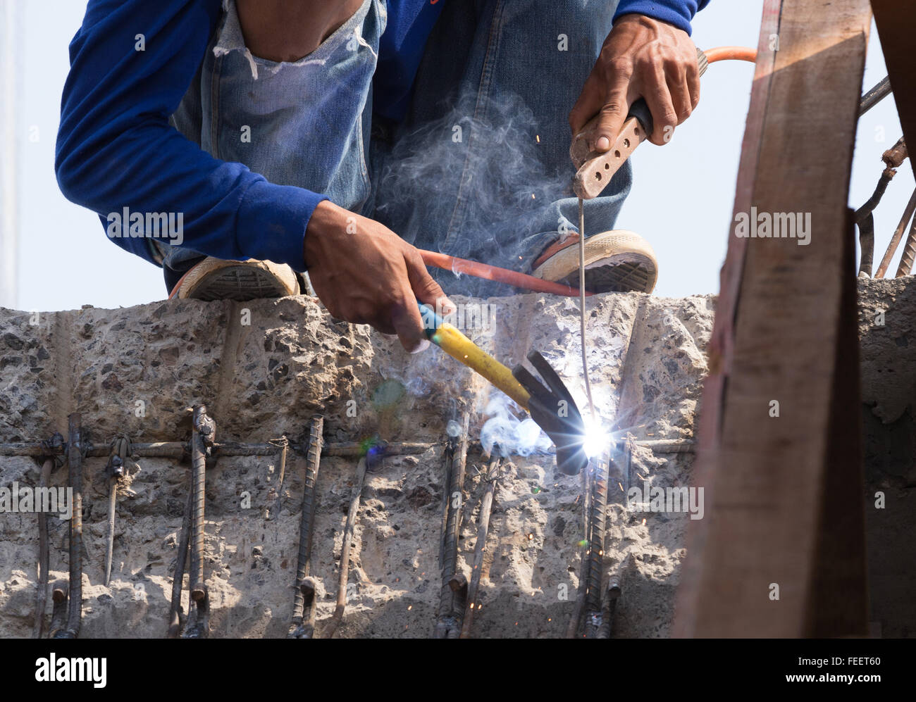 Lavoratore di saldatura metallica in acciaio al sito in costruzione Foto Stock