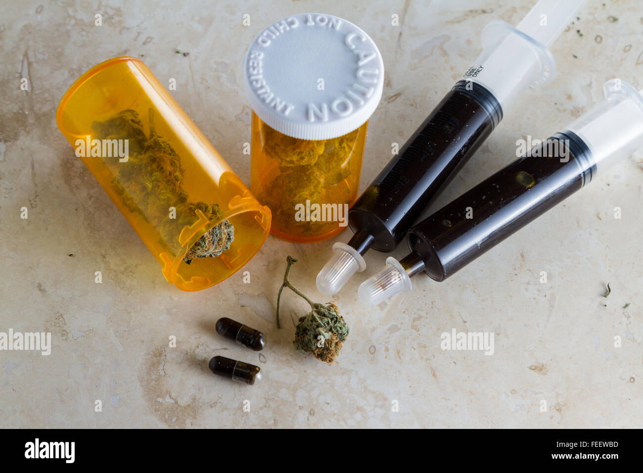 Close up di un olio costituito da olio essenziale della cannabis pianta della canapa con boccioli accanto e intorno la siringa Foto Stock