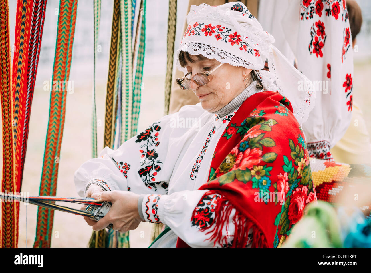 Gomel, Bielorussia - Settembre 12, 2015: Donna in nazionale bielorussa costume folk cinghia di tessitura Foto Stock