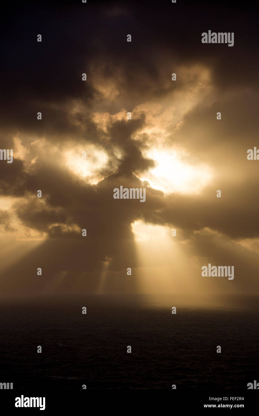 Il sole e la tempesta proveniente insieme e rendere i tratti di sun. Dyrholaey, Islanda Foto Stock